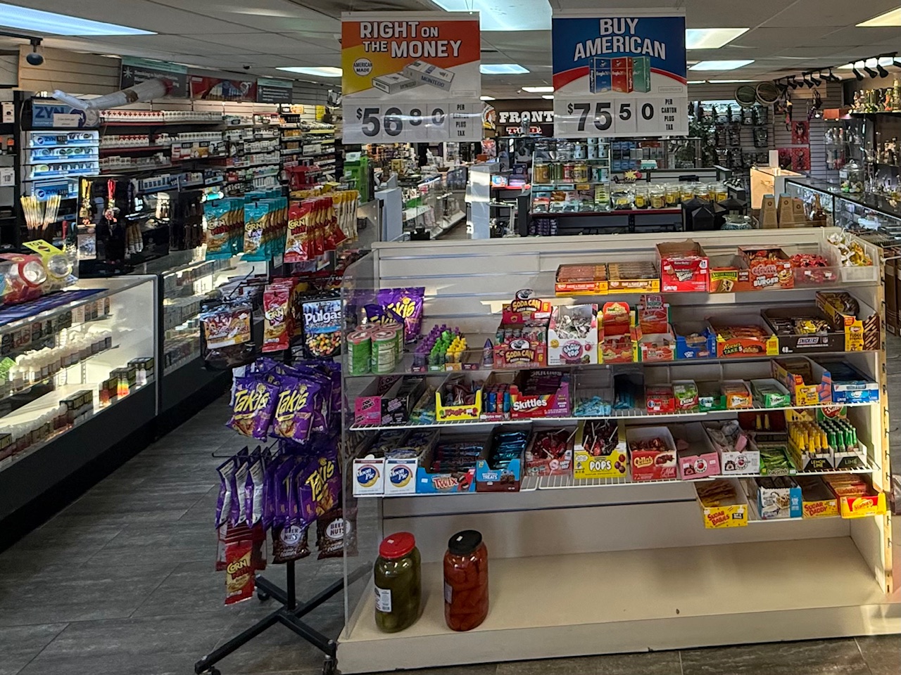 Cigarette wall with Marlboro and American banners above candy aisle