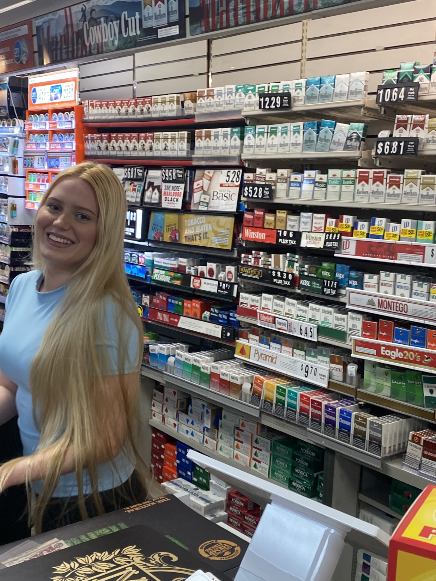 Friendly cashier at the Frontier Tobacco cigarette counter
